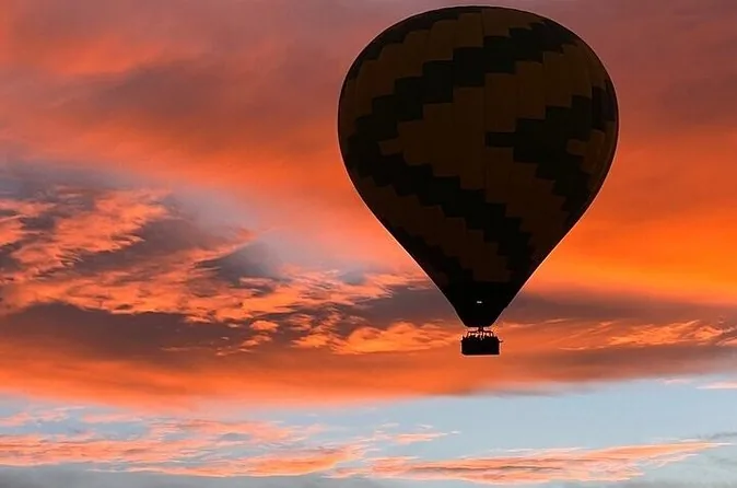A balloon silhouetted against an orange evening sky